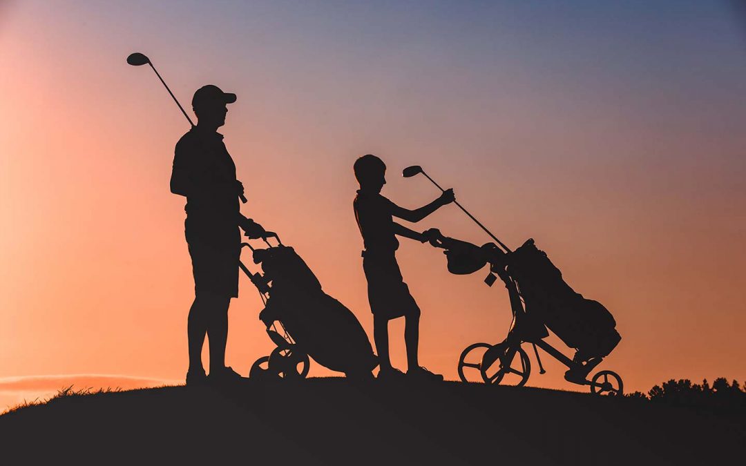 Golf Pro and child silhouetted against the morning sun